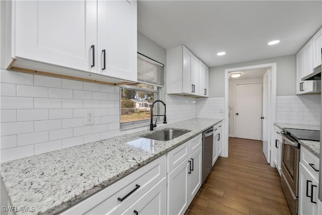 kitchen featuring appliances with stainless steel finishes, dark wood finished floors, white cabinets, and a sink