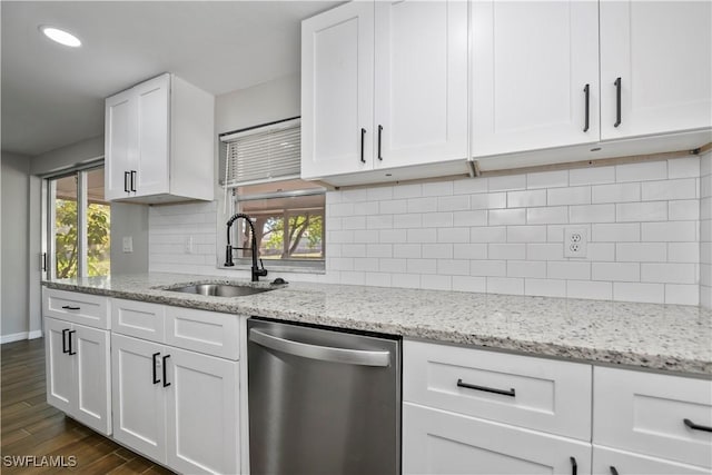 kitchen featuring white cabinets, decorative backsplash, dark wood-style floors, stainless steel dishwasher, and a sink