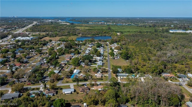 drone / aerial view featuring a water view and a wooded view