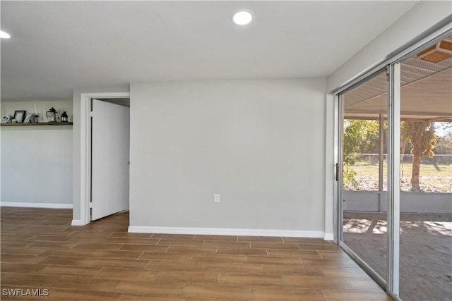 empty room featuring wood tiled floor, baseboards, and recessed lighting