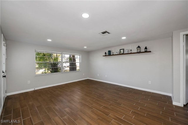 empty room with baseboards, dark wood-type flooring, and recessed lighting