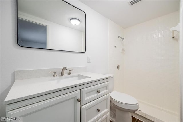 bathroom with visible vents, vanity, toilet, and walk in shower