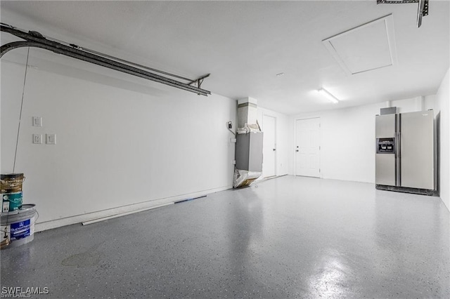 garage featuring stainless steel refrigerator with ice dispenser