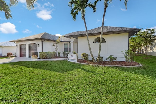 view of front of property with concrete driveway, a front lawn, an attached garage, and stucco siding