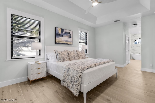 bedroom featuring light wood-style floors, baseboards, visible vents, and ceiling fan