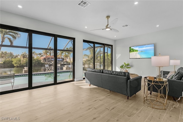 living room featuring light wood-style floors, visible vents, a ceiling fan, and recessed lighting