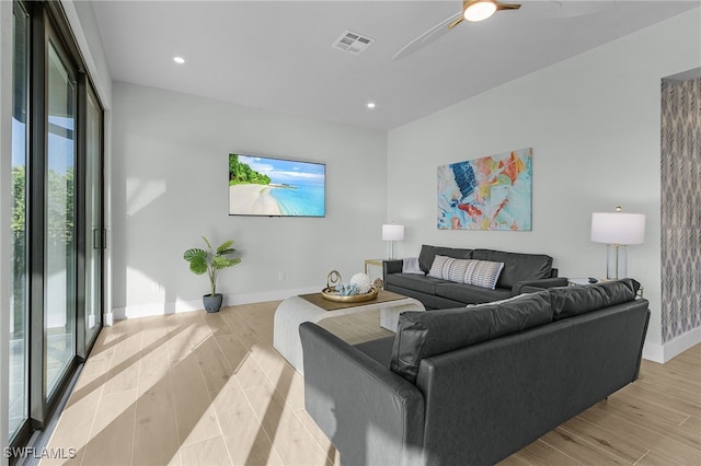 living area with baseboards, visible vents, and light wood-style floors