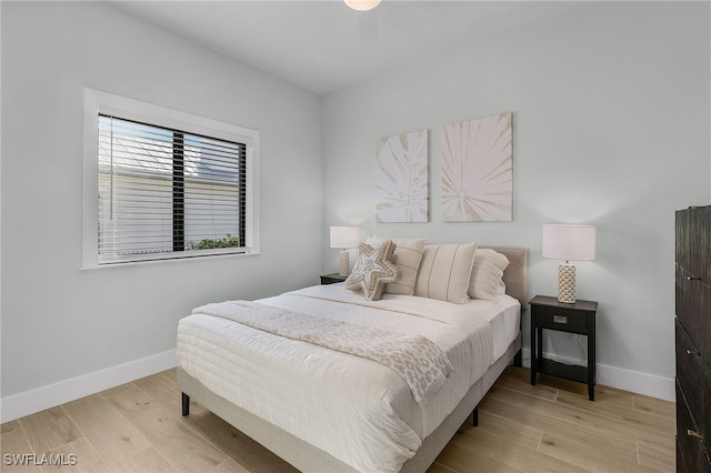 bedroom featuring baseboards and light wood finished floors