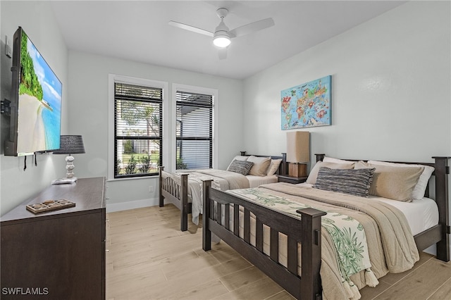 bedroom featuring ceiling fan, light wood finished floors, and baseboards