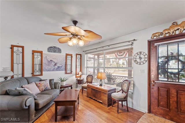 living area with a healthy amount of sunlight, ceiling fan, and light wood finished floors