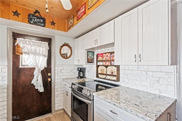 kitchen featuring tasteful backsplash, light stone counters, stainless steel range with electric cooktop, wooden ceiling, and white cabinets