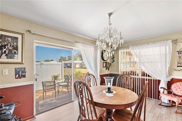 dining area with light wood finished floors and a notable chandelier