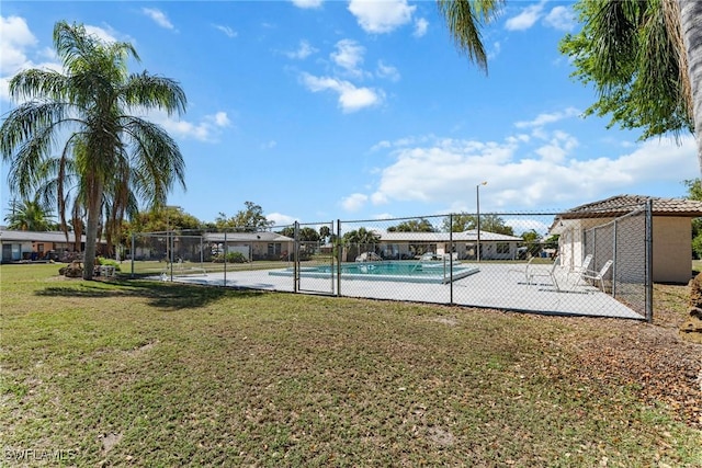 view of pool featuring fence and a lawn