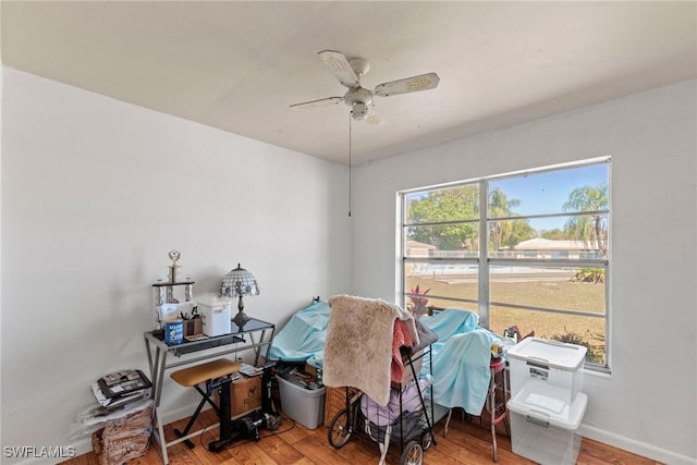 miscellaneous room featuring baseboards, wood finished floors, and a ceiling fan