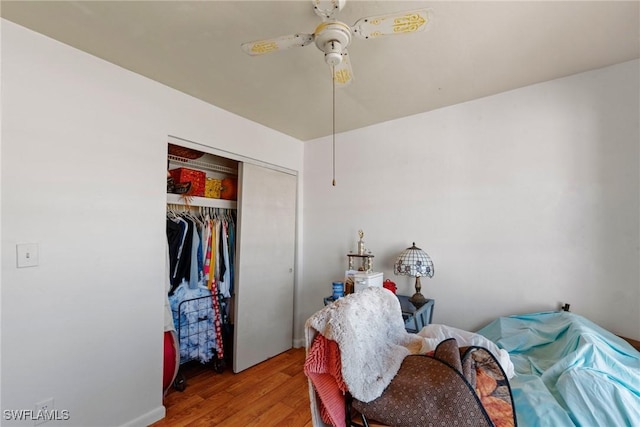 bedroom featuring a closet, wood finished floors, and a ceiling fan