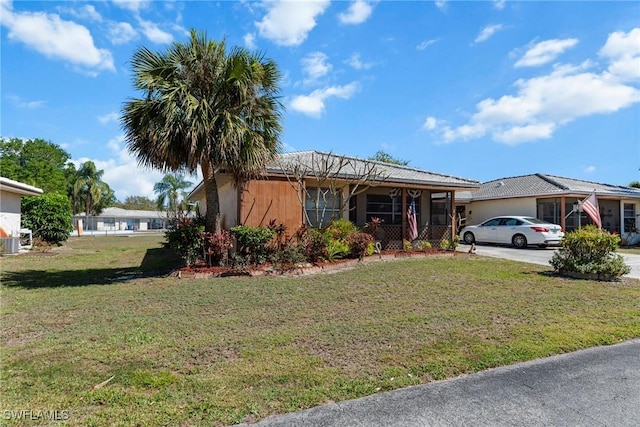 view of front facade with concrete driveway and a front lawn