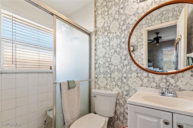 full bathroom with vanity, toilet, a shower stall, and wallpapered walls