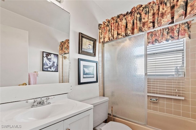 full bathroom featuring combined bath / shower with glass door, toilet, and vanity