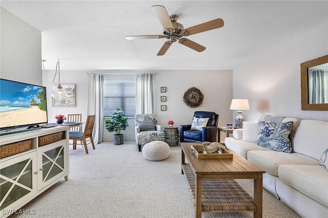 living area featuring light carpet and ceiling fan