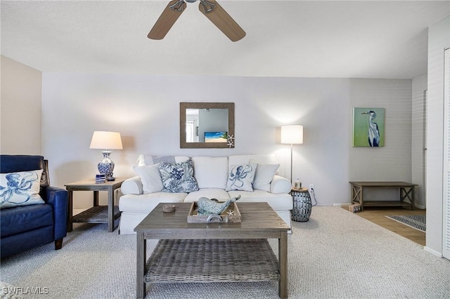 carpeted living area featuring ceiling fan