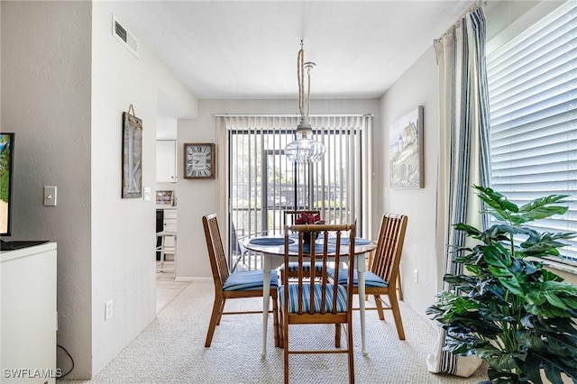 dining space with visible vents and an inviting chandelier