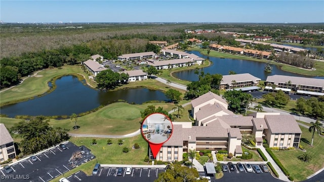 birds eye view of property with golf course view and a water view