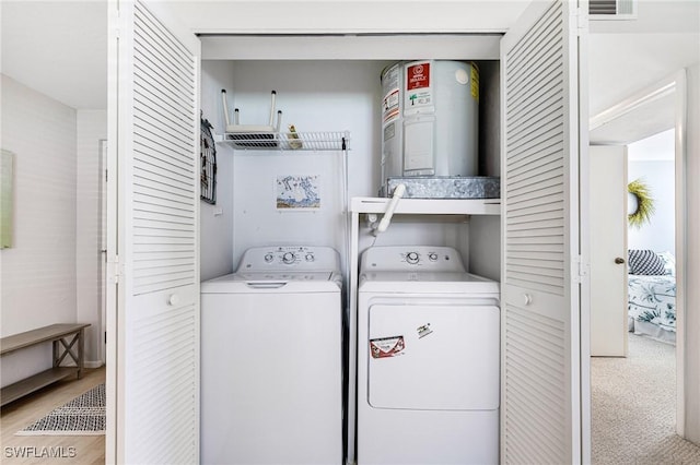 clothes washing area with laundry area, separate washer and dryer, and visible vents