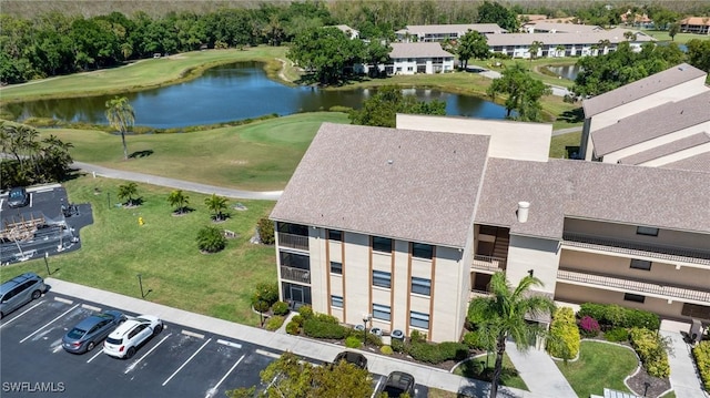 drone / aerial view with view of golf course and a water view