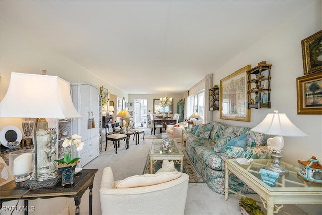 living room with light carpet and a notable chandelier