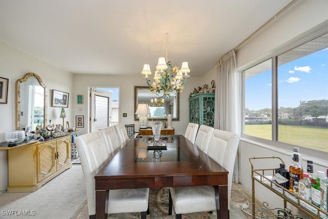 dining room featuring light carpet and an inviting chandelier