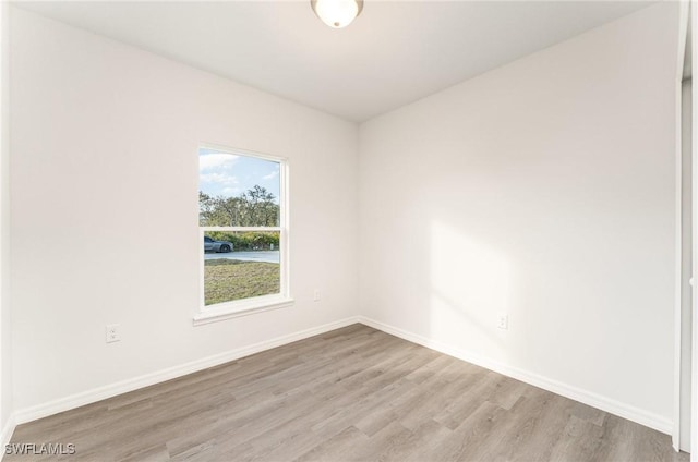 unfurnished room with light wood-style flooring and baseboards