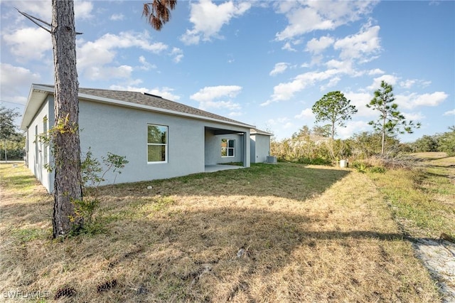 back of property featuring stucco siding and a lawn