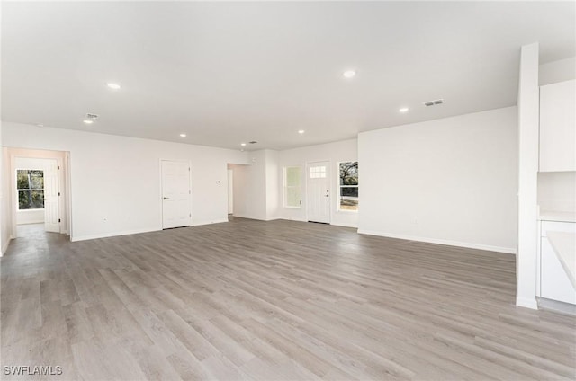 unfurnished living room featuring light wood-type flooring, visible vents, and recessed lighting