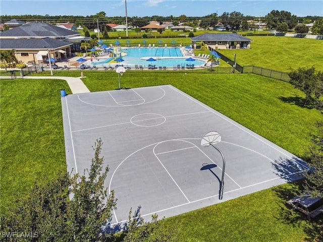 view of basketball court featuring community basketball court, a community pool, a lawn, and fence