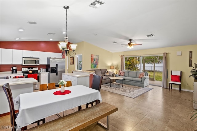 dining room featuring light tile patterned floors, visible vents, lofted ceiling, and baseboards