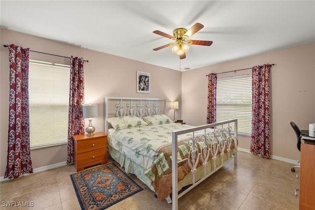 tiled bedroom with baseboards and a ceiling fan