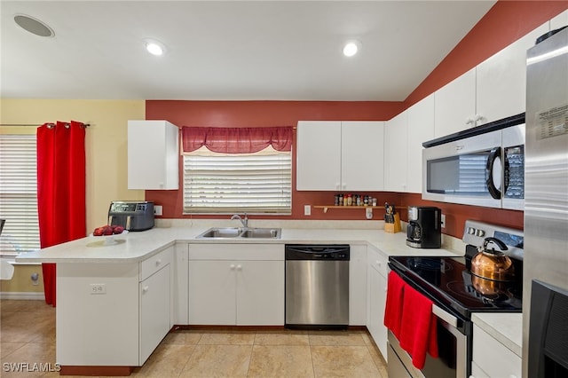 kitchen with appliances with stainless steel finishes, light countertops, and a peninsula