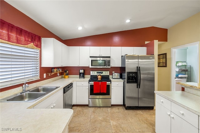 kitchen featuring a sink, stainless steel appliances, white cabinets, light countertops, and vaulted ceiling