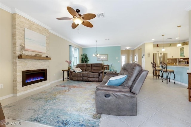 living room with light tile patterned flooring, a fireplace, visible vents, baseboards, and crown molding