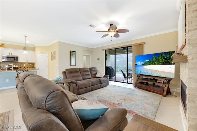 living room with light tile patterned floors, ornamental molding, visible vents, and a ceiling fan