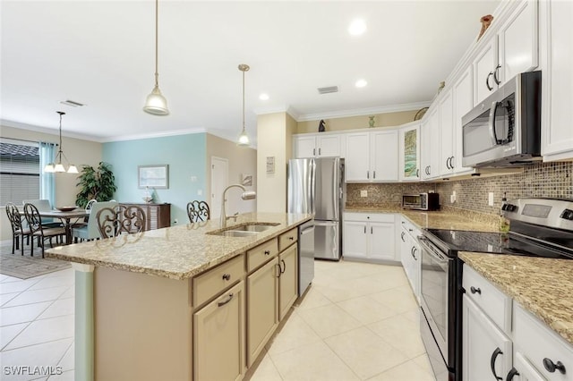 kitchen with light tile patterned floors, a sink, hanging light fixtures, appliances with stainless steel finishes, and backsplash