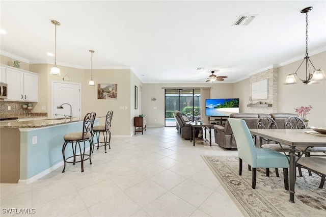 dining room with ceiling fan, visible vents, and crown molding