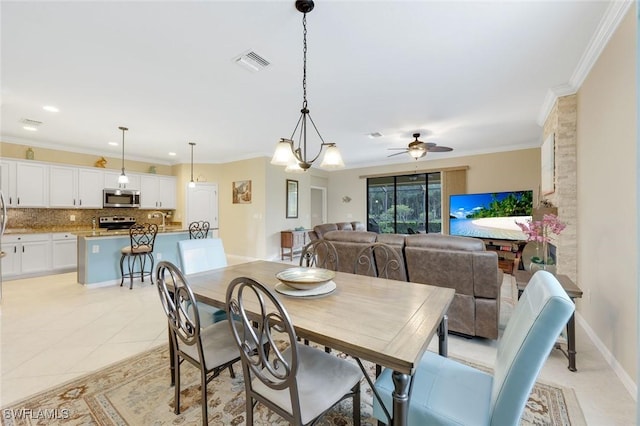 dining area with crown molding, light tile patterned floors, visible vents, a ceiling fan, and baseboards