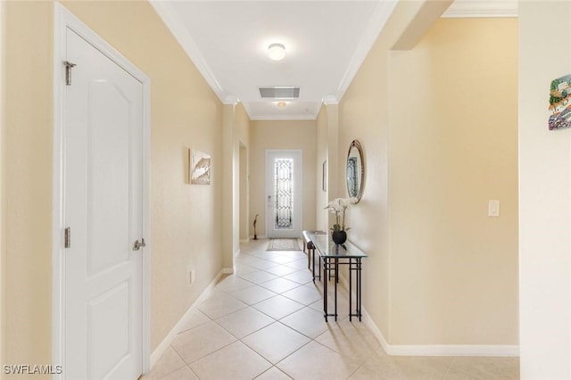 hallway with light tile patterned floors, ornamental molding, visible vents, and baseboards