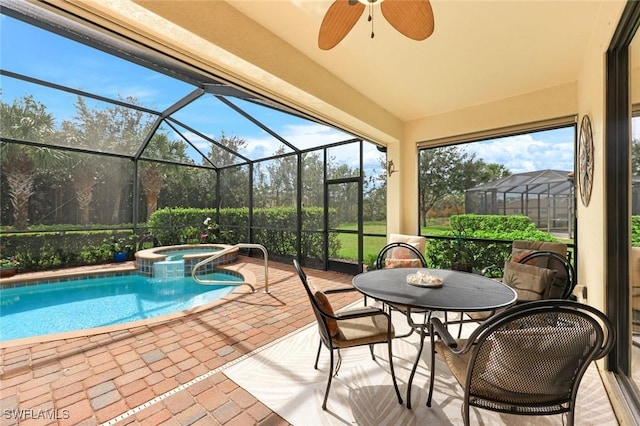 view of pool with glass enclosure, a pool with connected hot tub, a ceiling fan, and a patio