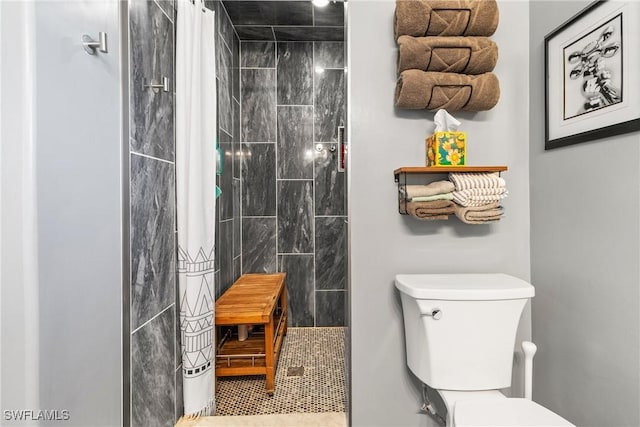 bathroom featuring toilet and a tile shower