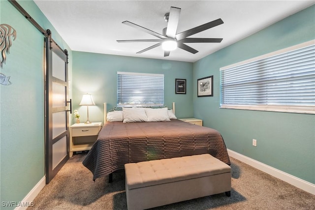 carpeted bedroom featuring a barn door, baseboards, and ceiling fan