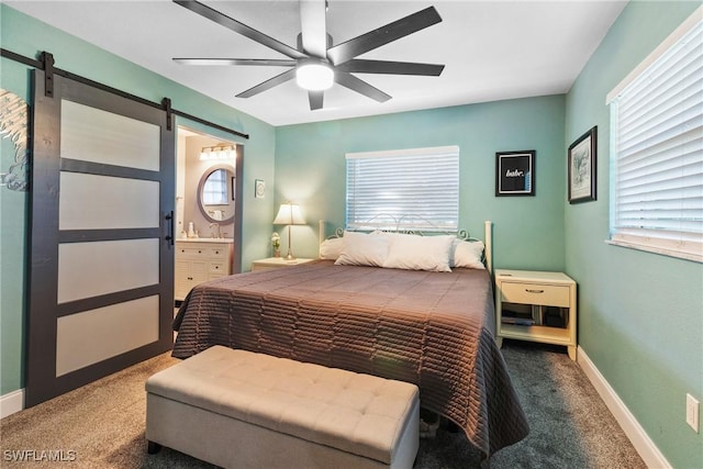 bedroom with a barn door, multiple windows, baseboards, and carpet floors