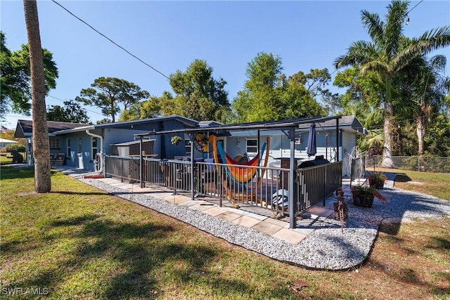 back of property featuring a lawn and fence