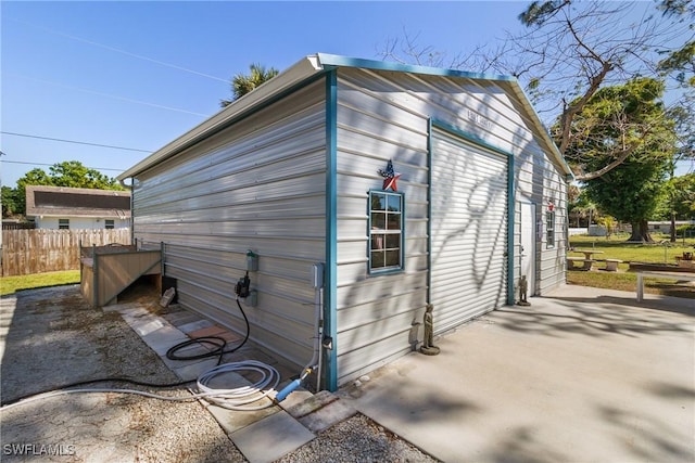 view of outdoor structure with an outbuilding and fence